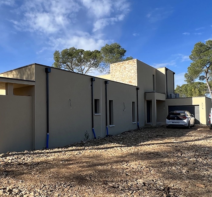 Maison contemporaine avec enduit clair et partie de façade en pierre